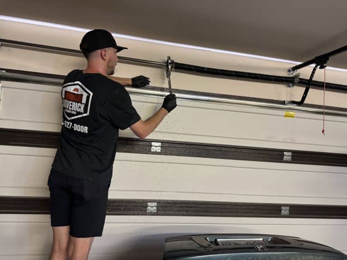 Maverick Overhead Door worker repairing a garage door spring.